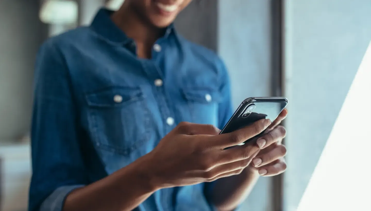 woman with blue shirt using a cell phone to send a fax