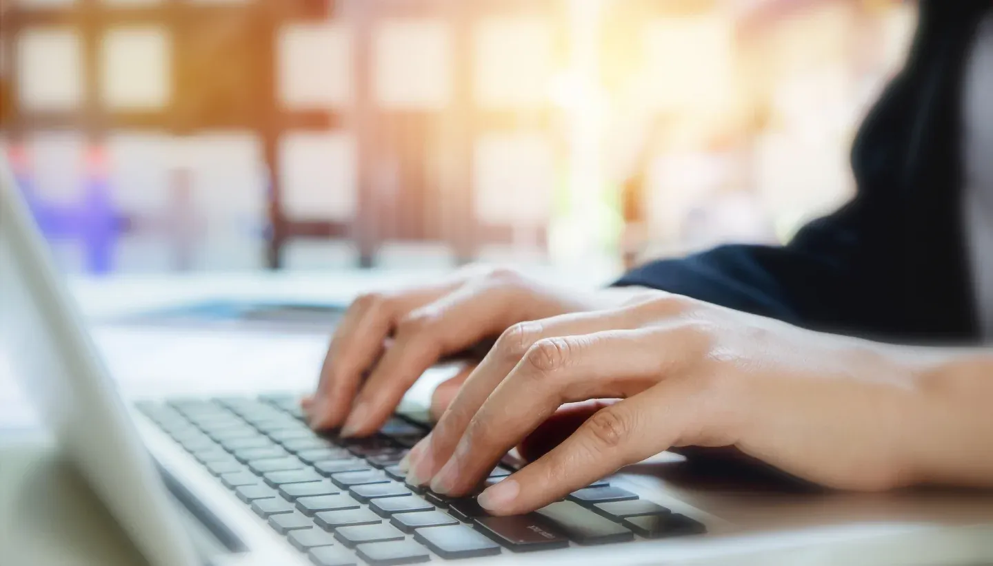 Hands on a laptop keyboard