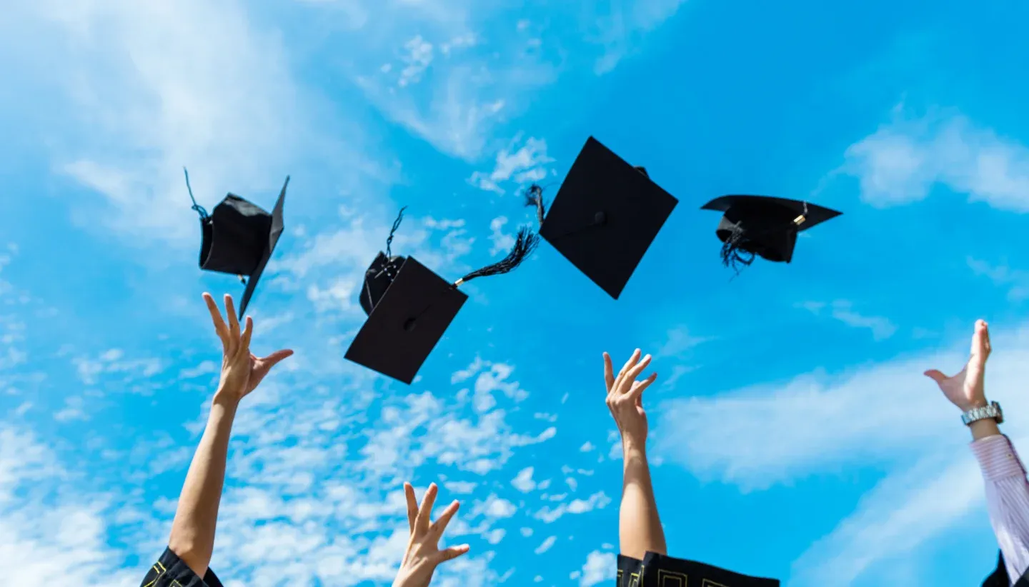 Graduation hats thrown in the air