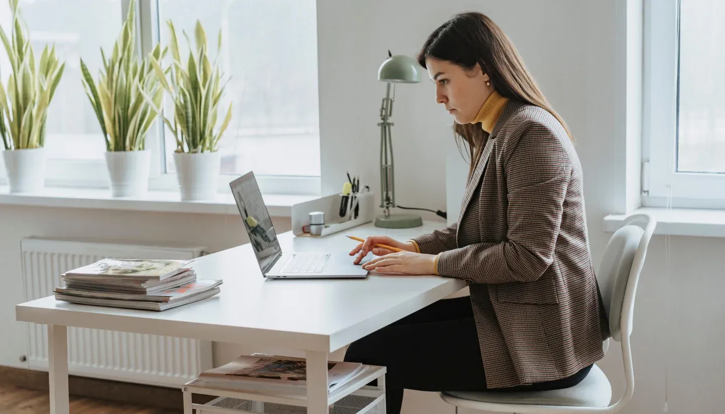 Woman looking at her laptop while at her desk